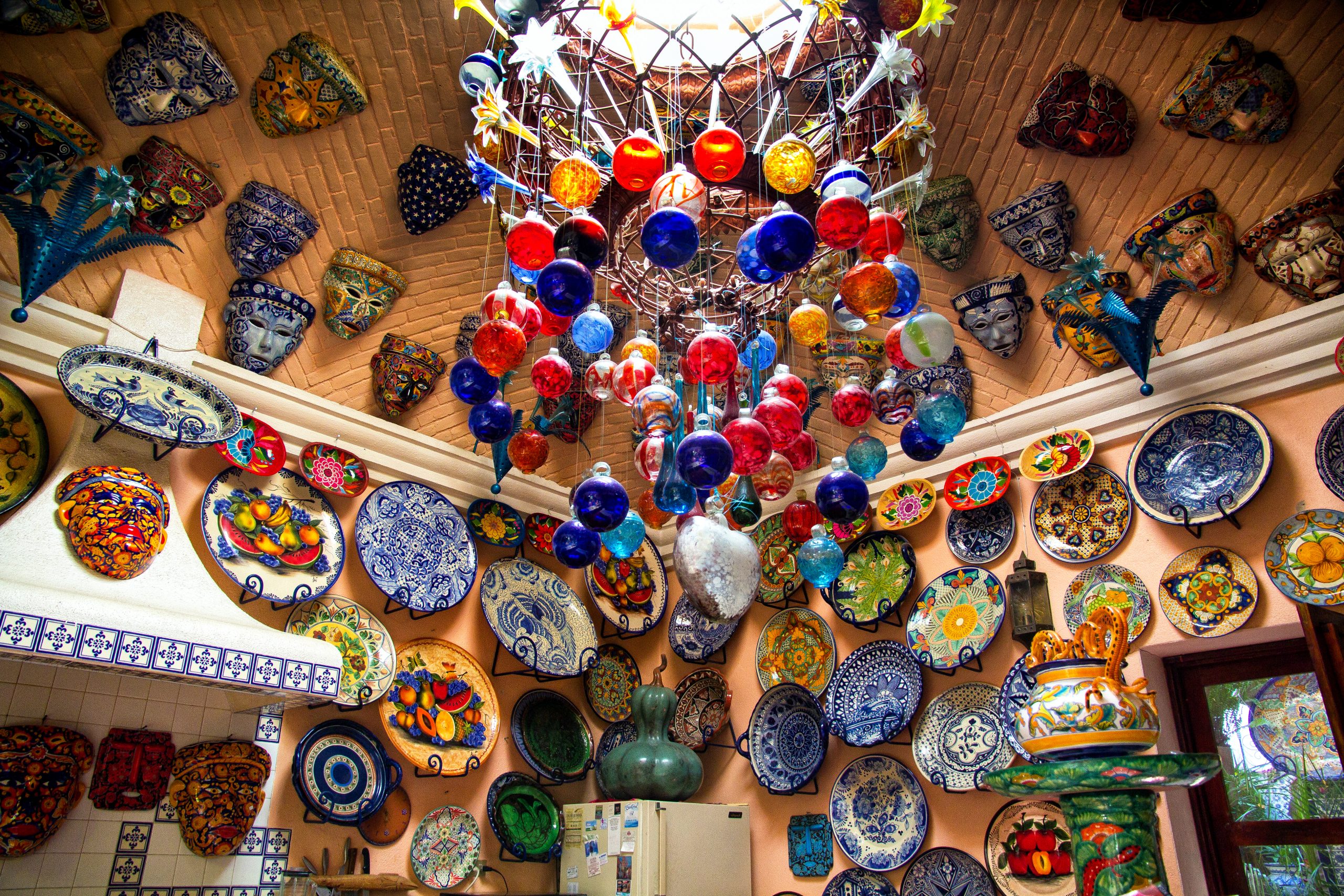 Colorful ceramics and glass decorations on ceiling and walls.